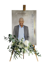 Funeral portrait print on easel with white and green flower tribute