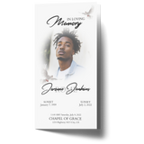 Trifold memorial card front with portrait, dove accents, and memorial dates in script.