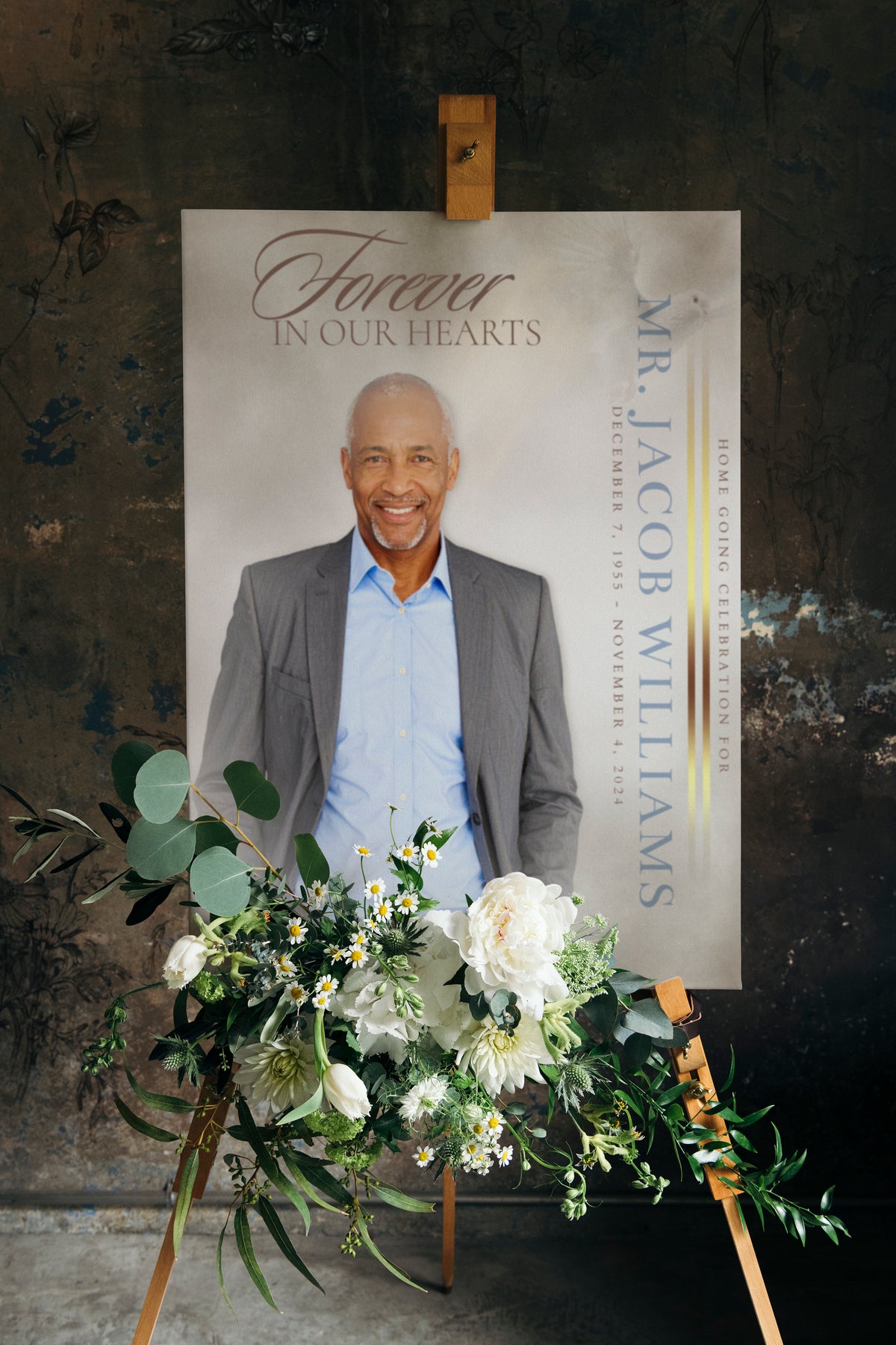 Funeral portrait print on easel with flower arrangement and name banner